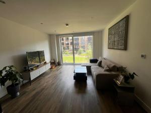 a living room with a couch and a large window at sPARSH in London