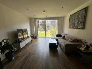 a living room with a couch and a large window at sPARSH in London