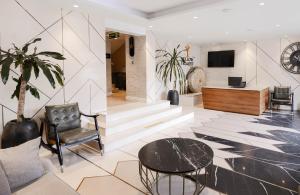 a lobby with a chair and a table and a tv at Yellow Trumpet Iris Maitama in Abuja