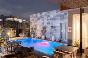 a large swimming pool with tables and chairs in a room at Yellow Trumpet Iris Maitama in Abuja