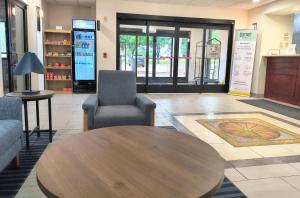 a lobby with a wooden table and two chairs at Grander Inn & Suites by IHG in Tyler