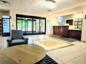 a lobby with a table and a chair and a counter at Grander Inn & Suites by IHG in Tyler