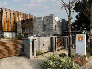 a building with a wooden fence in front of it at Yellow Trumpet Iris Maitama in Abuja