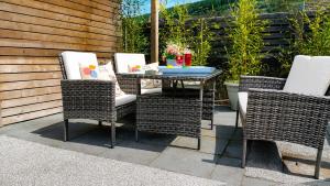 three wicker chairs and a table on a patio at Afan Forest Retreat Bikes, Pets, Family,Workers in Cymmer