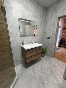a bathroom with a sink and a mirror at Апартаменти Фігля з видом на гори in Mukacheve +69 photos