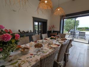 a dining room with a table with flowers on it at Maison d'Hôtes Le Clos de Bacchus in Julienne