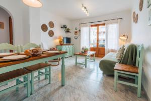a living room with a table and a couch at Apartamentos Obelisc in Can Picafort