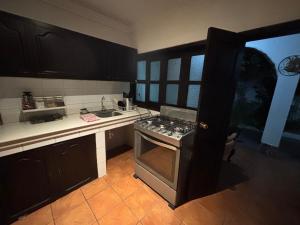 a kitchen with black cabinets and an oven in it at Casa de la Torre in Antigua Guatemala