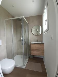 a bathroom with a shower and a toilet and a sink at Appartement Neuf avec Balcon in Hendaye