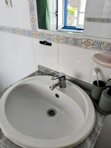 a white sink in a bathroom with a window at Refúgio do Xekeraute in Piódão +37 photos