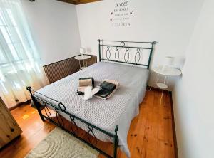 a bedroom with a bed with a metal frame and two lamps at Refúgio do Xekeraute in Piódão