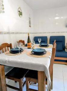 a table with a white table cloth and a bottle of wine at Refúgio do Xekeraute in Piódão