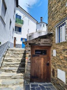 a stone building with a wooden door on it at Refúgio do Xekeraute in Piódão