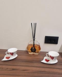 two coffee cups and a vase on a wooden table at Damhomeitaly in Modena