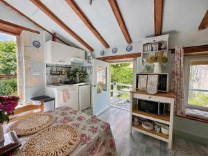 a kitchen with a table and a microwave in a room at La Colline de Tilleul - Les Deux Puits - Cosy Cottage with swimming pool near Aubeterre in Saint-Romain