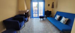 a living room with a blue couch and chairs at Hanioti Home in Hanioti