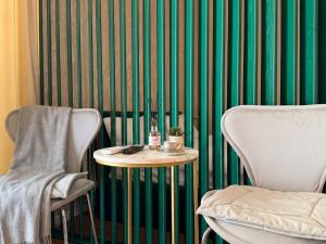 a green and white striped wall with a table and chairs at New stail centru in Bălţi +2 photos