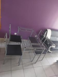 two chairs and a glass table in front of a purple wall at Pavillon - T2 Duplex avec Terrasse et Parking in Montagnat