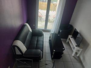 a living room with a couch and a television at Pavillon - T2 Duplex avec Terrasse et Parking in Montagnat