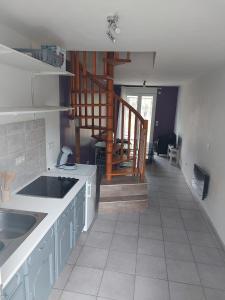 a kitchen with a sink and a staircase in the background at Pavillon - T2 Duplex avec Terrasse et Parking in Montagnat