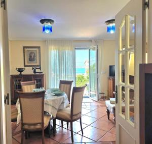 a dining room with a table and chairs with a view of the ocean at Apartamento Ora al Mare - 32002 in Pedreña