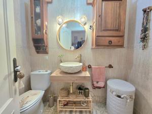 a bathroom with a sink and a toilet and a mirror at Apartamento Ora al Mare - 32002 in Pedreña