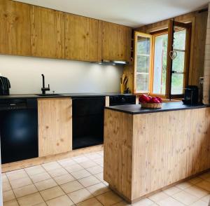 a kitchen with wooden cabinets and a black counter top at Chalet Royal in Les Diablerets +6 photos