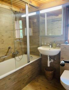 a bathroom with a tub and a sink and a shower at Chalet Royal in Les Diablerets