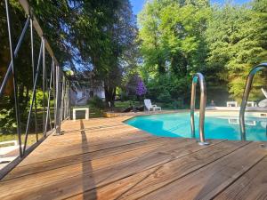 a wooden deck next to a swimming pool at Le Pavillon dans le Parc in Saulxures-sur-Moselotte