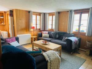 a living room with couches and a coffee table at Chalet Royal in Les Diablerets