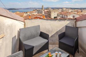 a balcony with two chairs and a table at The Lake View - Terrazza Panoramica Vista Lago in Marta