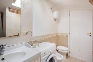 a bathroom with a white sink and a toilet at The Lake View - Terrazza Panoramica Vista Lago in Marta