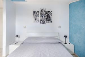 a bedroom with a bed and a painting of a tiger at The Lake View - Terrazza Panoramica Vista Lago in Marta