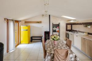 a kitchen with a table with a vase of flowers on it at The Lake View - Terrazza Panoramica Vista Lago in Marta +7 photos