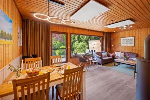 a dining room and living room with a table and chairs at Ortheide 68 in Böddenstedt