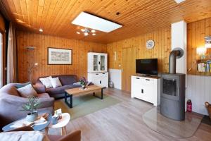 a living room with a couch and a tv at Ortheide 68 in Böddenstedt