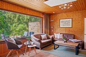a living room with a couch and chairs and a large window at Ortheide 68 in Böddenstedt +42 photos