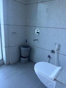 a bathroom with a white toilet in a room at Hotel 7 Square in Surat
