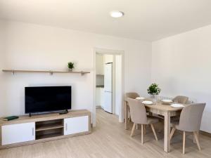 a living room with a table with chairs and a television at La Villa de Miera - 12809 in Ajo