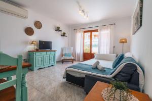 a bedroom with a bed and a tv and a table at Apartamentos Obelisc in Can Picafort
