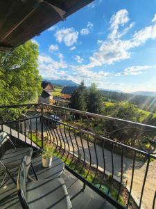 a balcony with chairs and a view of the valley at Sądelska Chałpa in Murzasichle