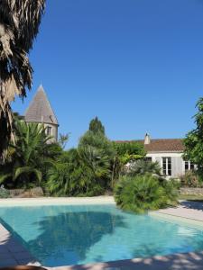 a swimming pool in front of a house at Le Moulin de la Borderie in Saint-Pierre-dʼOléron