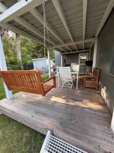 a porch with a swing and a table and chairs at Tiny house am Wald eingezäunt in Meißendorf