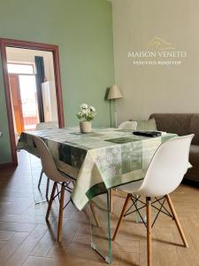 a dining room with a glass table and chairs at Maison Veneto Vesuvius Rooftop in Torre Annunziata