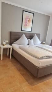 a bedroom with a large bed with a table at Harlacher-Mühle in Stetten