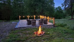 a fire pit in a yard with chairs and lights at Cabana Codrii Maramuresului in Giuleşti