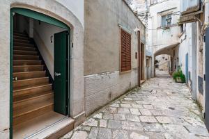 an alley way with stairs and a green door at 15min Polignano Puglia Historical Center Terrace in Conversano