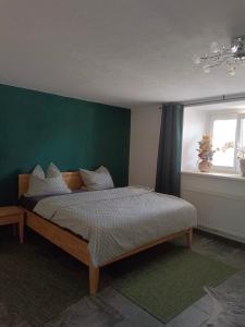 a bedroom with a bed and a green wall at Ferienhaus Strohmayer in Schweiggers