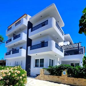 a white building with balconies on the side of it at Alonia Hotel in Kalamaki