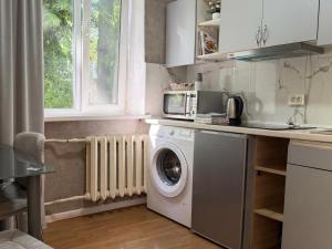a kitchen with a washing machine and a microwave at New stail centru in Bălţi